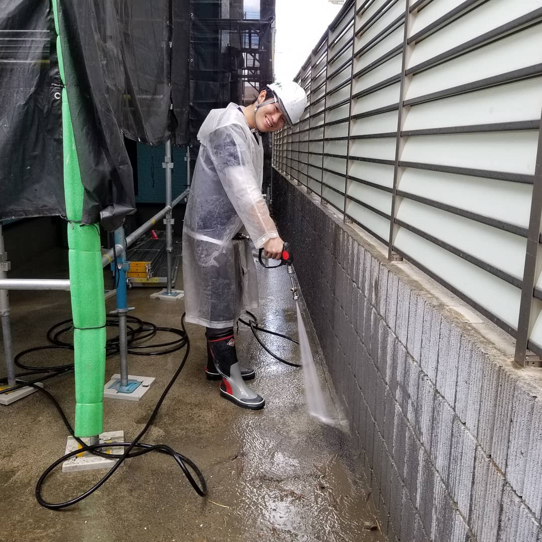 高圧洗浄を行う職人の現場風景